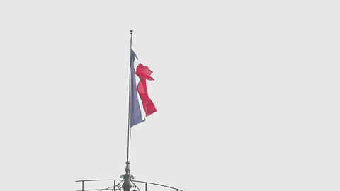 French tricolor flag waving in the wind above the city, patriotism, freedom