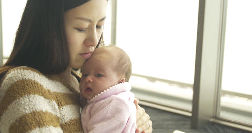 Asian mother holds her new born baby
