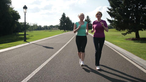 Jogging senior women running parkway in sportswear