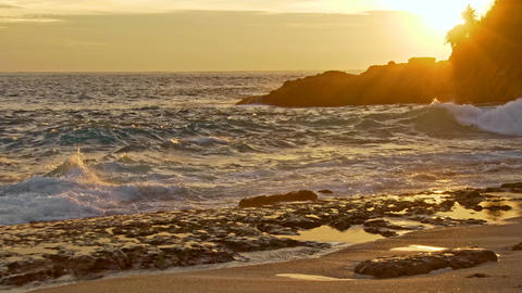Sea waves and rocky shore at sunset