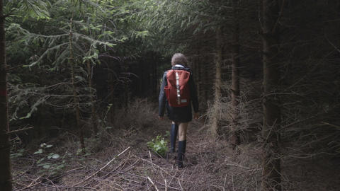 Young woman walk through the dark forest