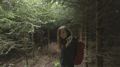 Young woman walk through the dark forest in the evening
