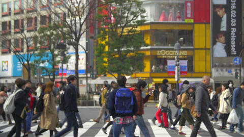 Walking through crowds at Shibuya crossing Tokyo