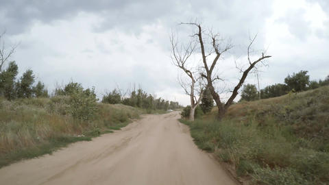 Rear view of car driving along a rural dirt road