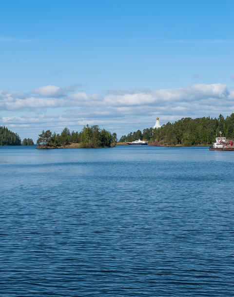 The panorama of the Bay on the island with ships and a Church far away on the