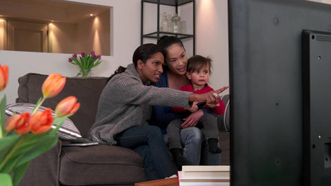 Happy Gay People Homosexual Couple Women Watching TV With Daughter