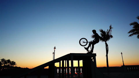 BMX Biker Silhouette Doing a No Hands Jump