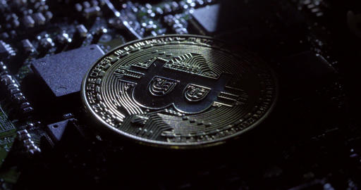 Rotating shot of shadows moving over a casascius bitcoin on a circuit board