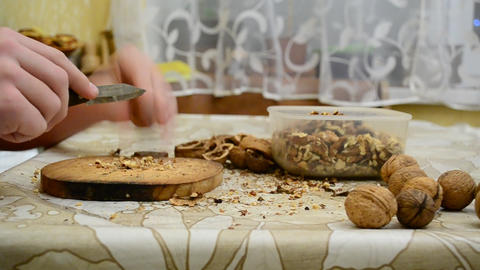 Teenager cracking walnuts with a knife