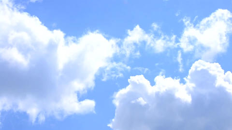 White cirrus and cumulus clouds move on background of blue sky