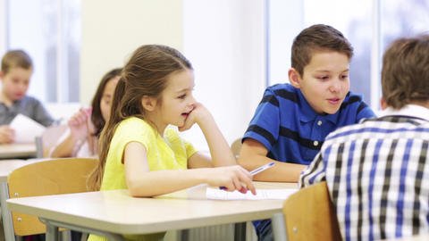 group of students with papers talking at school