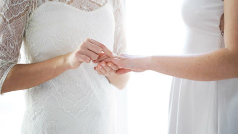 close up of lesbian couple hands with wedding ring