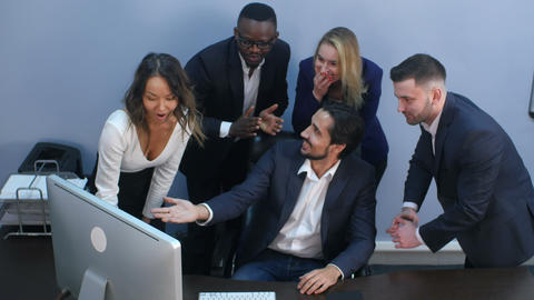 Portrait of shocked business team by the table looking at laptop in office