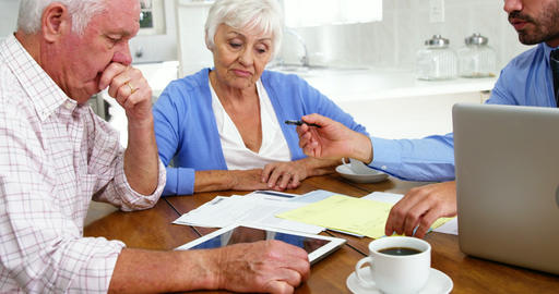 Mature couple filling some formal documents with man