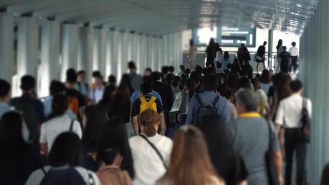 People going to the work in the business district at rush hour on the summer day