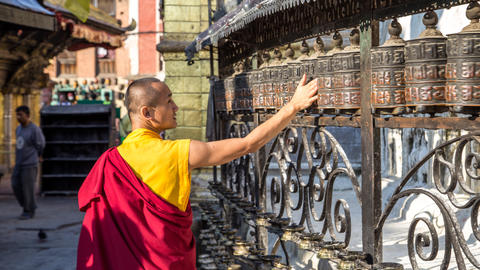 Monk spinning prayer wheels