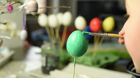 Young child painting easter eggs