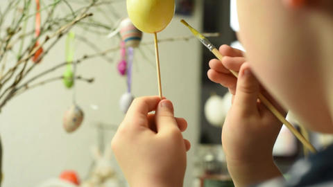 Young child painting easter eggs
