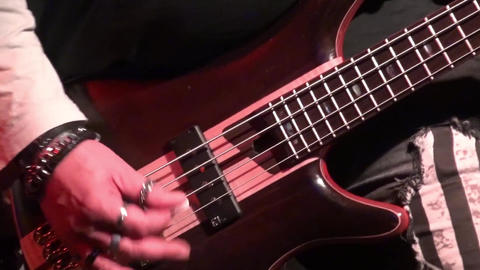 bass guitar in live action at a concert - rack focus - close up