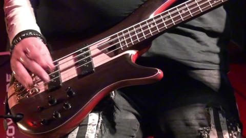 bass guitar in live action at a concert - rack focus - close up