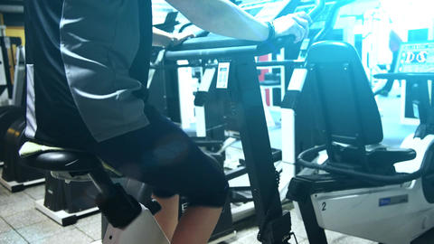 A girl exercising on a stationary bike in a gym