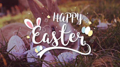 Easter white bunny with easter eggs sitting in the grass
