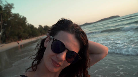 Happy girl spinning and dancing on beach at sunset