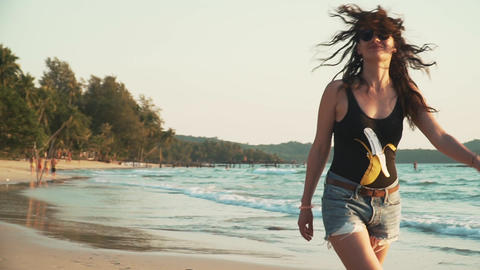Happy woman enjoys vacation on the beach at sunset
