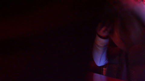 Bar in night club with bartender and visitors shot in low fps in nightclub