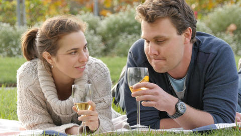 Romantic young couple in park drink wine celebrating marriage engagement