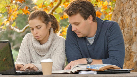Autumn day students study outdoors on laptop helping each other learn