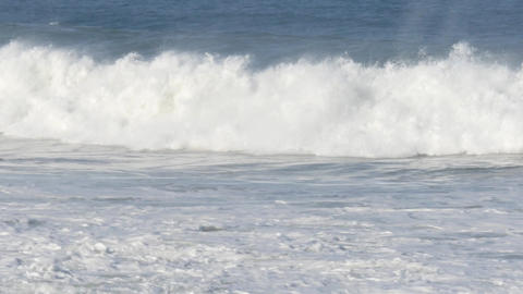 Large waves crashing out at sea creating big surf from storm