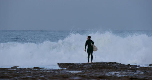Surfer looking at ocean waves before surfing