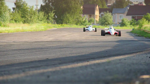Formula one race cars fallowing each other, taking turn