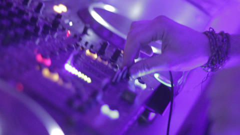 Dj's hands playing mix on sound board, platter spinning