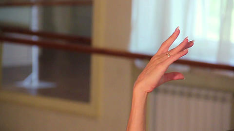 Close-up woman dancer lifts her arms gracefully above her head