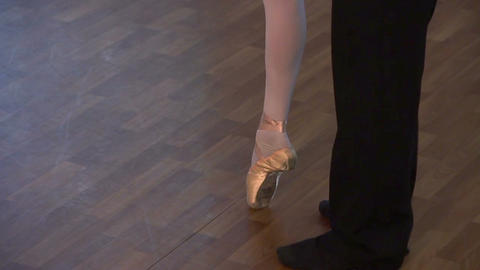 Couple's feet on the dance floor, man twirling woman around
