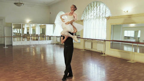 Couple ballet dancing, young man carrying ballerina on shoulder