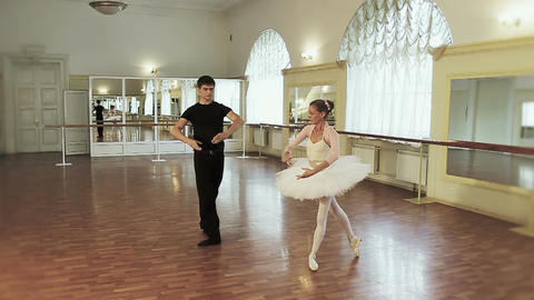 Young man and elderly woman dancing ballet synchronously in gym