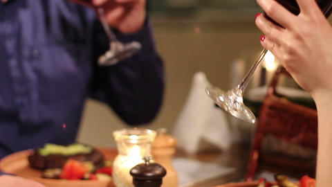 Couple on date clinking wineglasses and drinking in restaurant