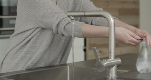 Woman washing hands with soap and hot water in kitchen, hygiene, Coronavirus pandemic prevention
