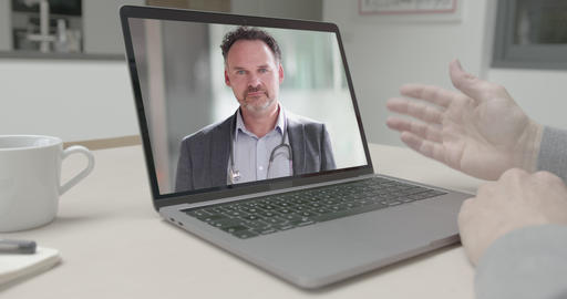 Online video call via laptop of male doctor consulting sick man talking in kitchen. Medicine,