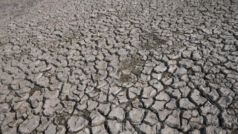 Panning shot of cracked dry clay soil, drought