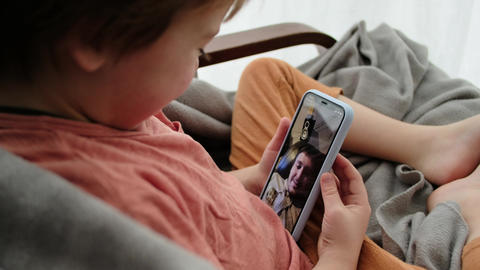 Little boy talks with father using videocall on smartphone