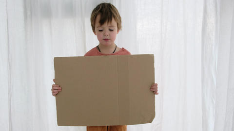 Upset boy holds cardboard sheet with space for template