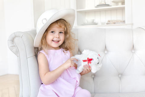 Charming girl in dress posing with toy
