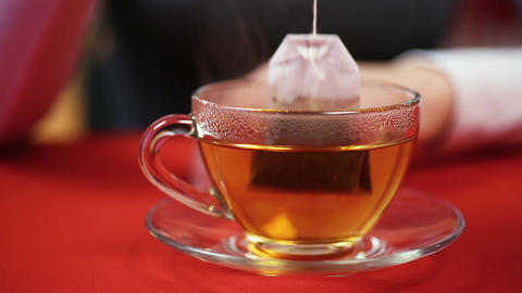 Teatime, female making black tea, putting teabag in a cup. Person feeling cold
