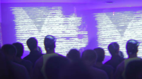 Night club crowded with people dancing, enjoying dj set, creative video effect