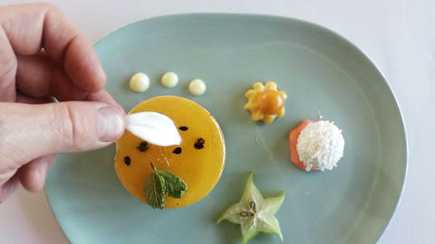 Hand of chef garnishing dessert food