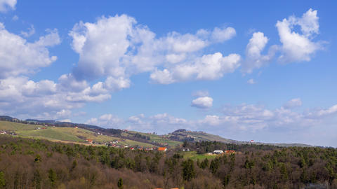 Aerial hyper, time lapse of moving clouds above rural landscape, hills with